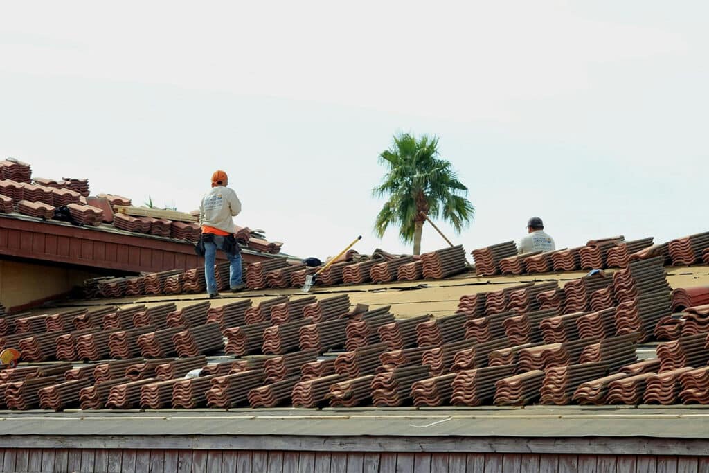 Workers installing roof tiles after a seamless field service management.