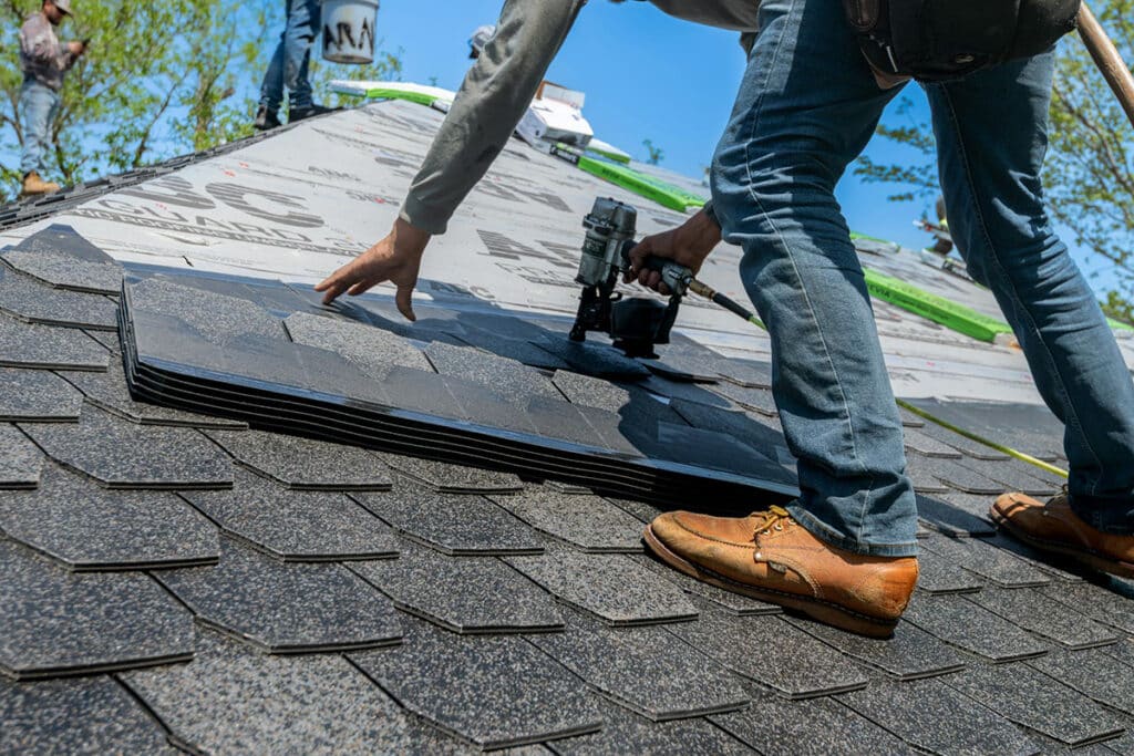 Expert roofer installing shingles, demonstrating the skill and efficiency that can impact a roofer salary per hour.