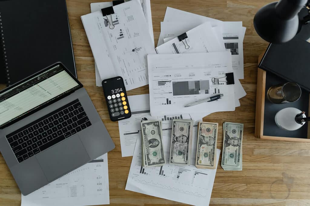 Financial documents, calculator, and money on a desk, reflecting the average roofer salary and earnings.
