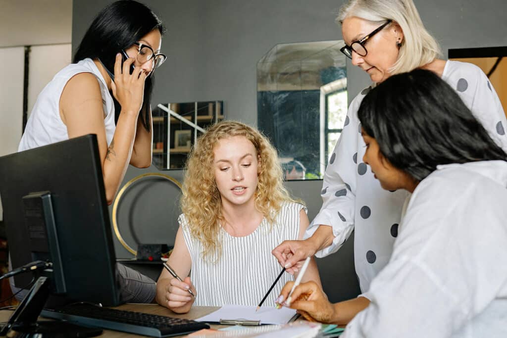 Team reviewing documents at a desk while using field service management software tools.