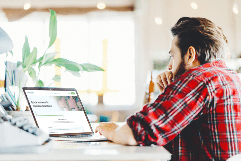 Man reading FAQ page on laptop